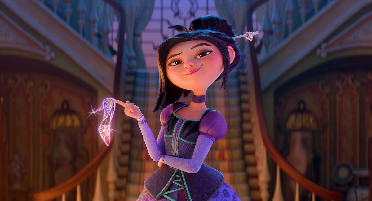 Animated girl in a purple dress stands confidently in a grand, ornately decorated hall, holding a sparkling magical wand in one hand. Elegant staircases frame the background, and warm lighting creates a whimsical atmosphere.