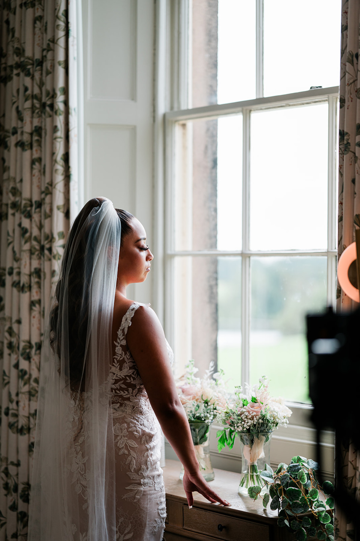 Demi looks out a window in her wedding dress.