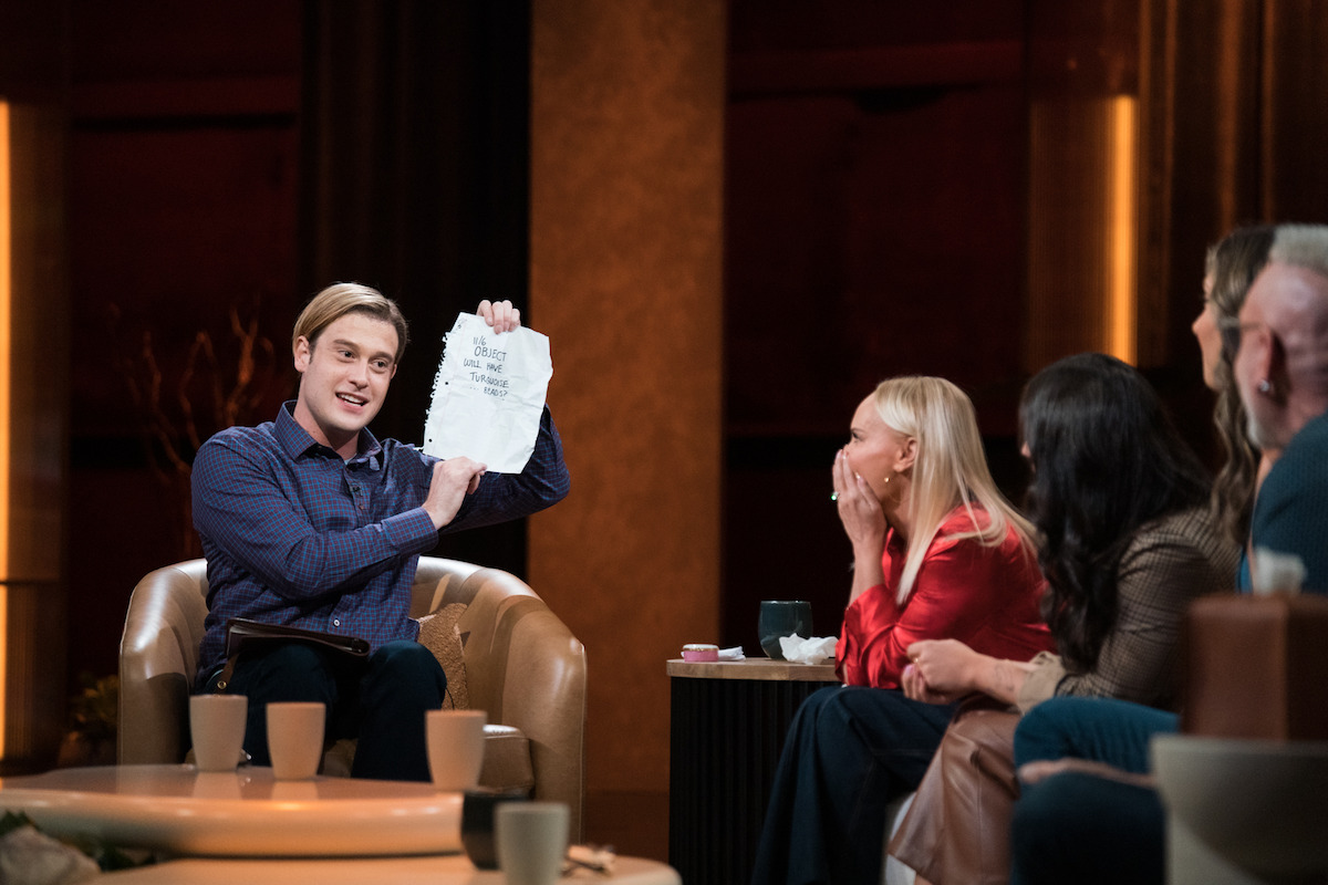 Tyler Henry holds up a paper with the words “11/6 Object will have turquoise … beads?” while Kristin covers her mouth in shock.