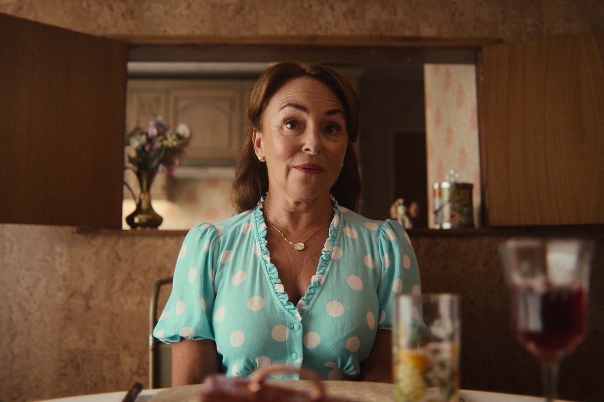 Samantha Spiro as Maureen Groff sits at a table in Season 4 of ‘Sex Education’