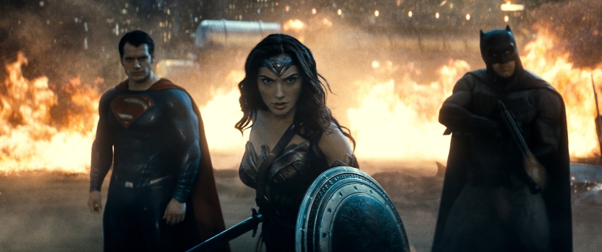 Superman, Wonder Woman, and Batman stand together with fire behind them in ‘Batman v Superman: Dawn of Justice’