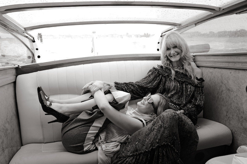 Alba Rohrwacher lies across Laura Dern's lap as they sit in a boat on the Venice canals.