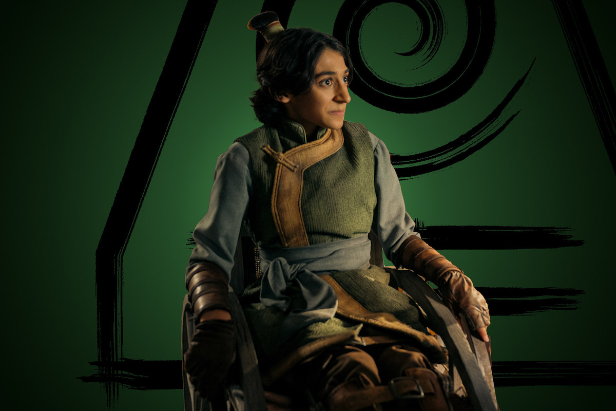 Lucian-River Chauhan as Teo sits in a wheelchair wearing green robes in season 1 of ‘Avatar: The Last Airbender’
