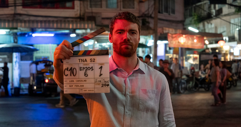 Gabriel Basso holds a clapboard for season 2 of 'The Night Agent'