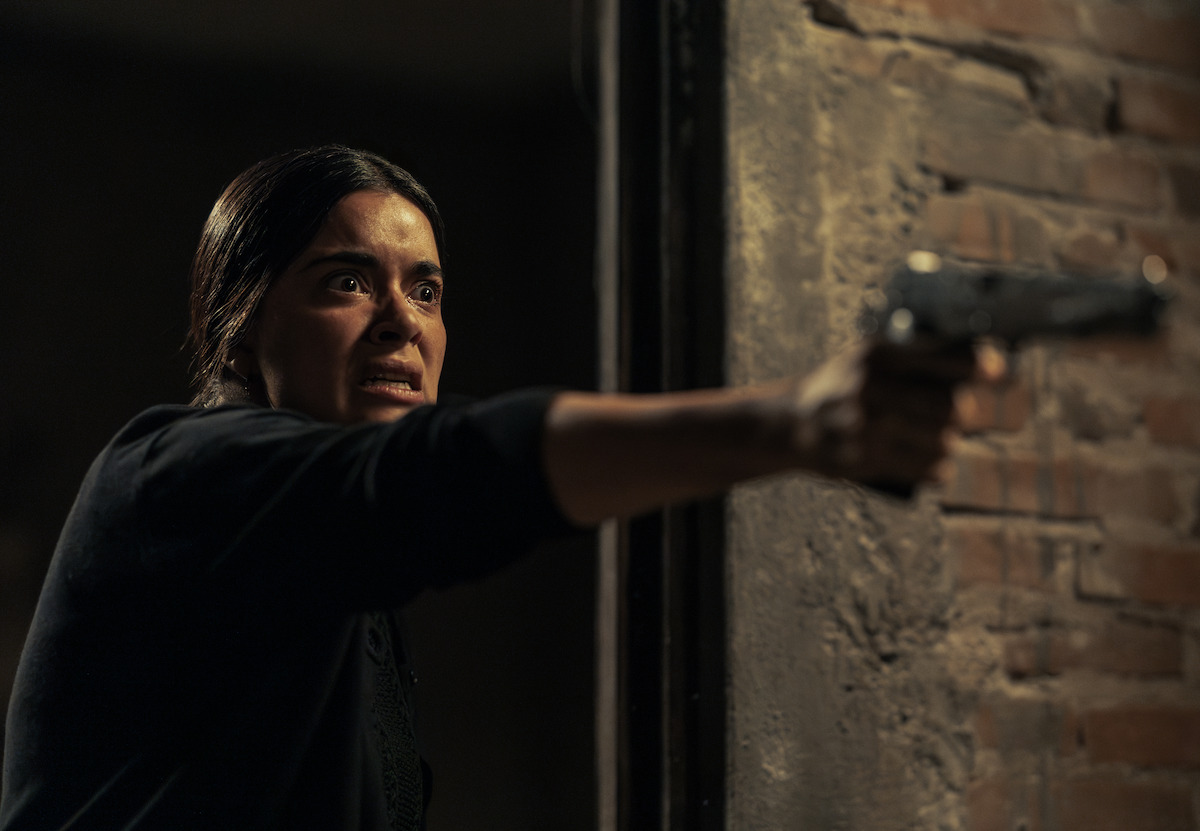 Paulina Gaitán as Serafina points a gun in a production still from ‘The Dead Girls’.