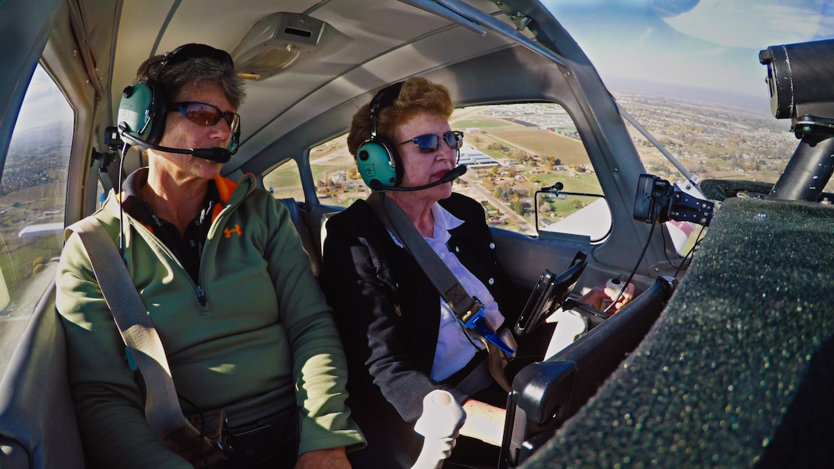 Two women with headsets in the cockpit of an aircraft