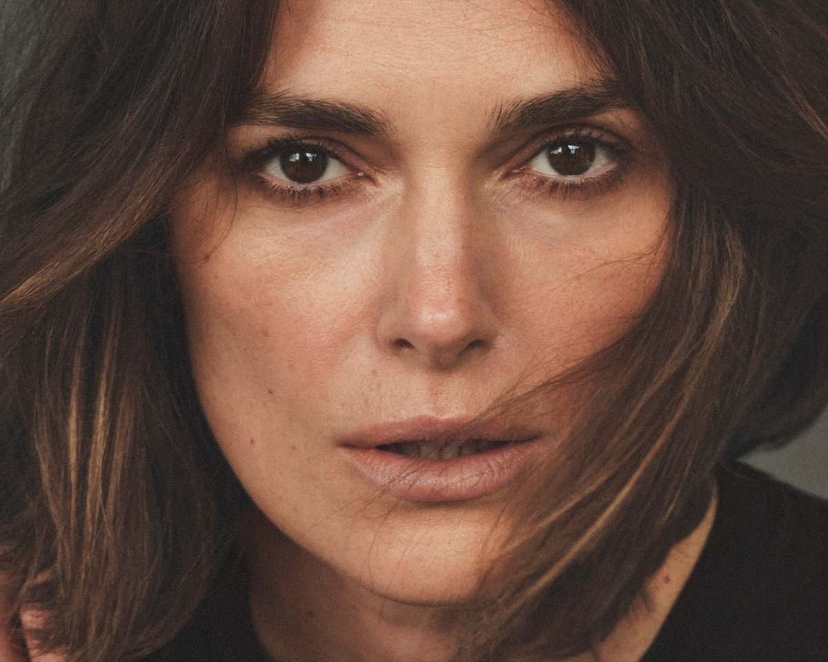 Keira Knightley wears a black top and looks directly at the camera. Fierce!