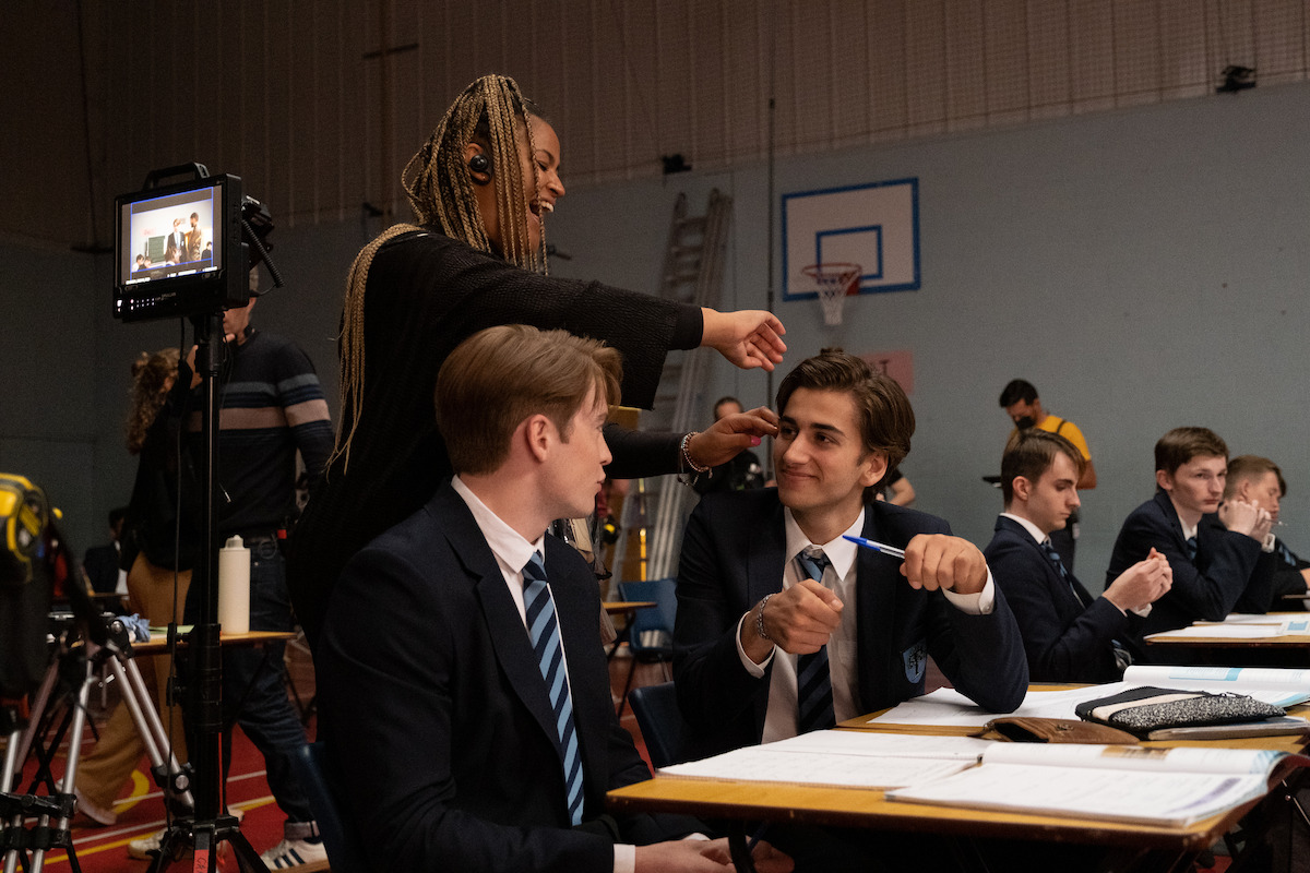 Kit Connor as Nick and Sebastian Croft as Ben sit at a desk together in Season 2 of ‘Heartstopper.’