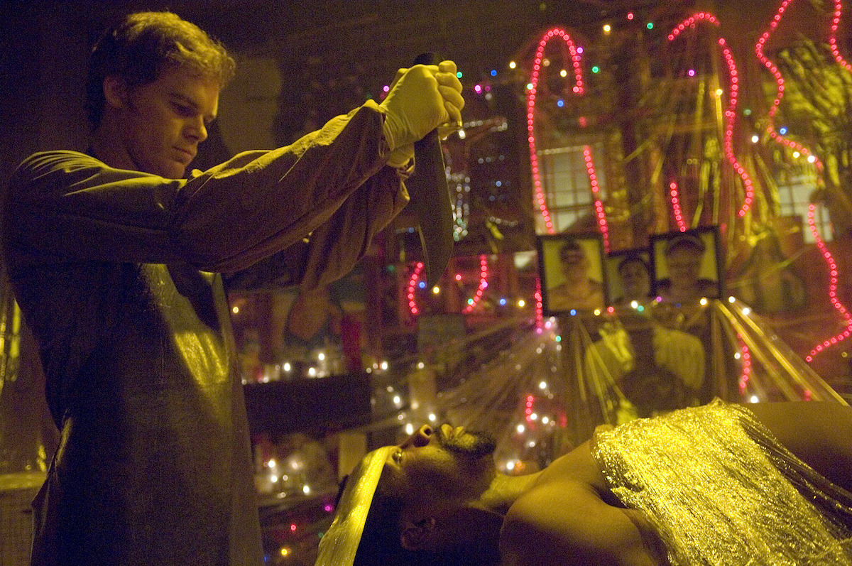 Michael C. Hall as Dexter holds a knife over a victims head.