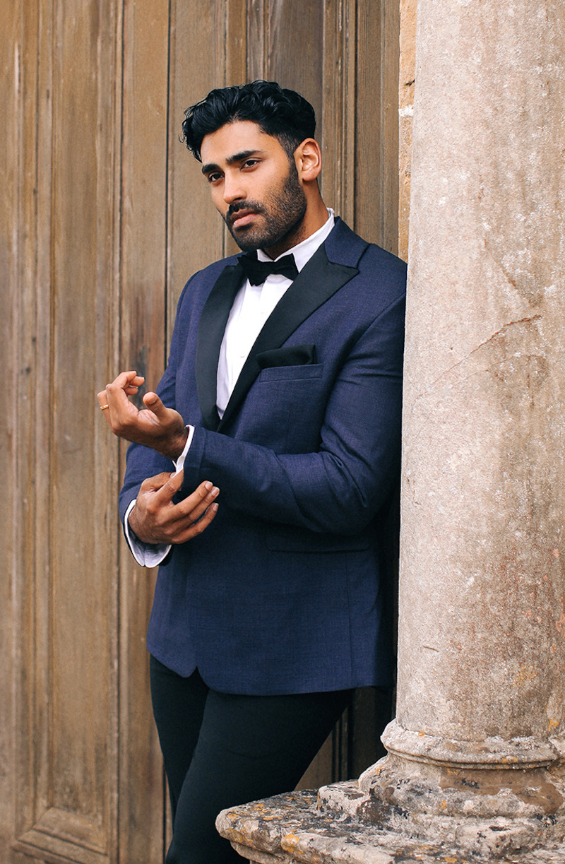 Woman in bridal dresses poses and looks off into the distance.