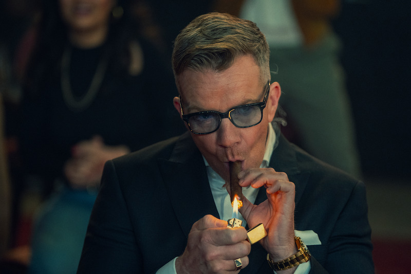 Max Beesley lights a cigar in Season 1 of ‘The Gentlemen.’