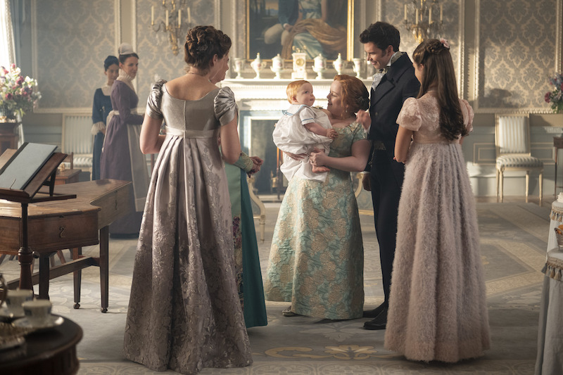 Sophie Lamont as Celia, Ruth Gemmell as Lady Violet Bridgerton, Polly Walker as Lady Featherington, Nicola Coughlan as Penelope Featherington, Luke Thompson as Benedict Bridgerton, and Florence Hunt as Hyacinth Bridgerton in 'Bridgerton' Season 4.