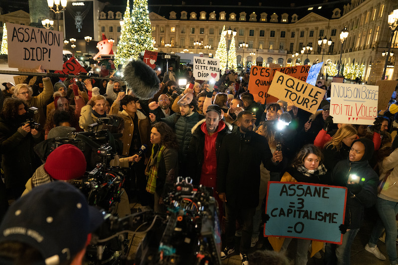 A crowd gathers in Paris in Season 3 of 'Lupin.'