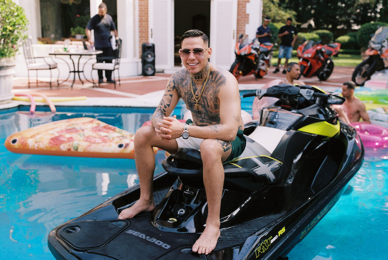 Homem posa para foto em um jetsky, parado dentro de uma piscina