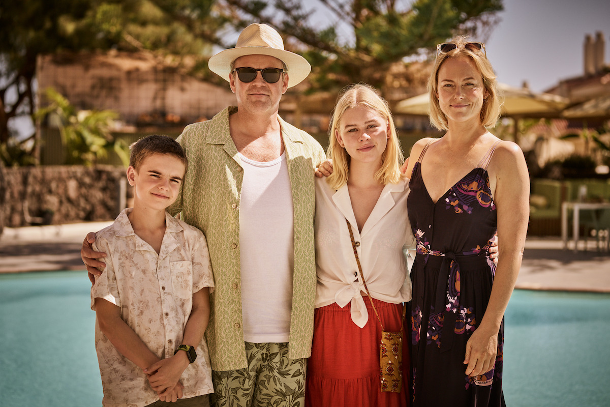 Bernard Storm Lager, Anders Baasmo Christiansen, Alma Günther and Ingrid Bolsø Berdal stand in front of a resort pool in holiday clothes from the series 'La Palma.'