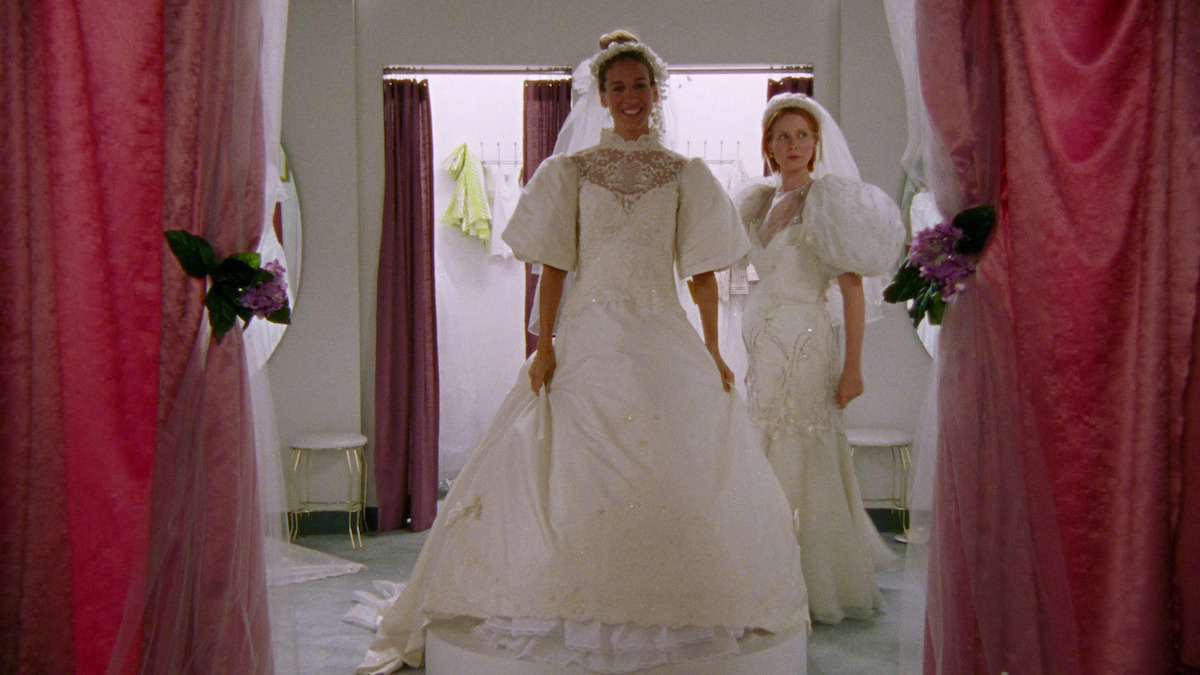 Carrie looking happy in a wedding dress. 