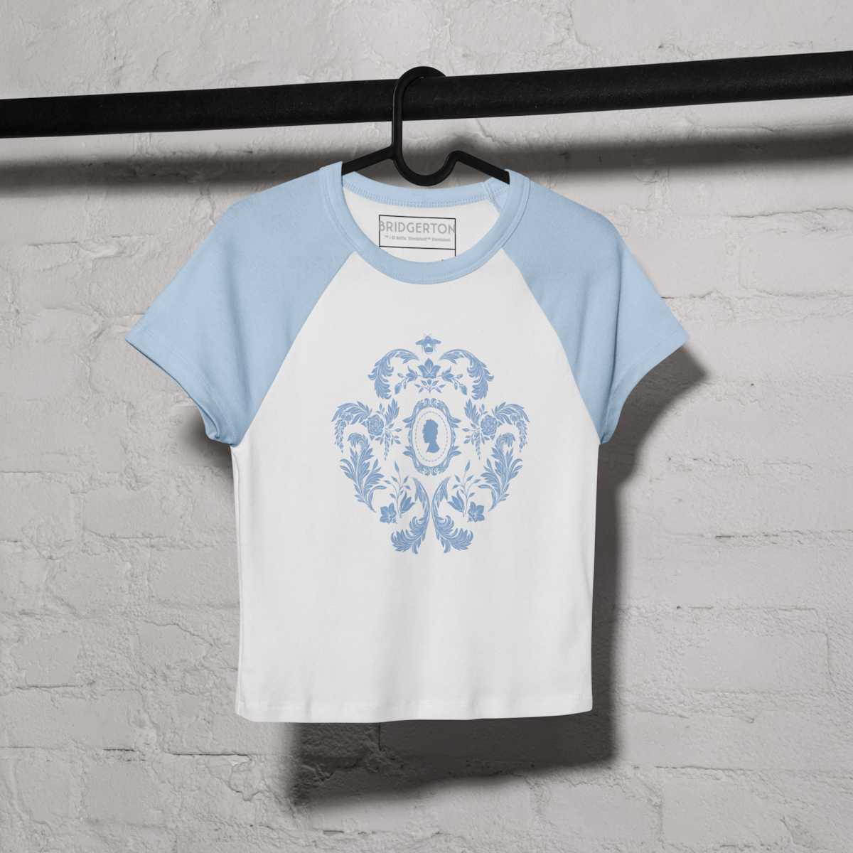 A vanity table with pastel teacup, saucer, tea, macarons in glass bowl, eye mask, notebook, headband, ornate glassware, and decorative floral items in soft, vintage-inspired colors and feminine setting.