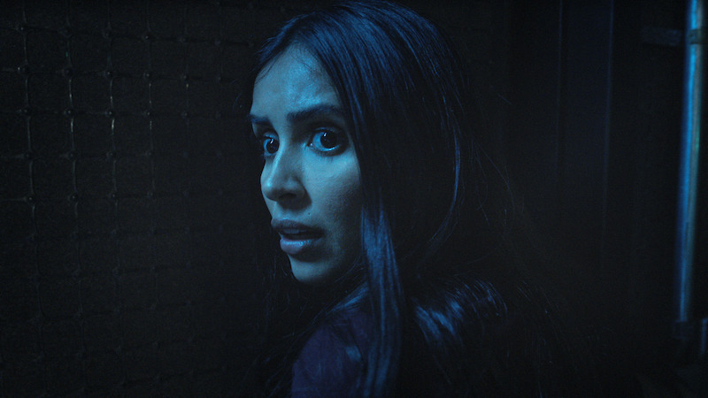 A woman standing in the shadows