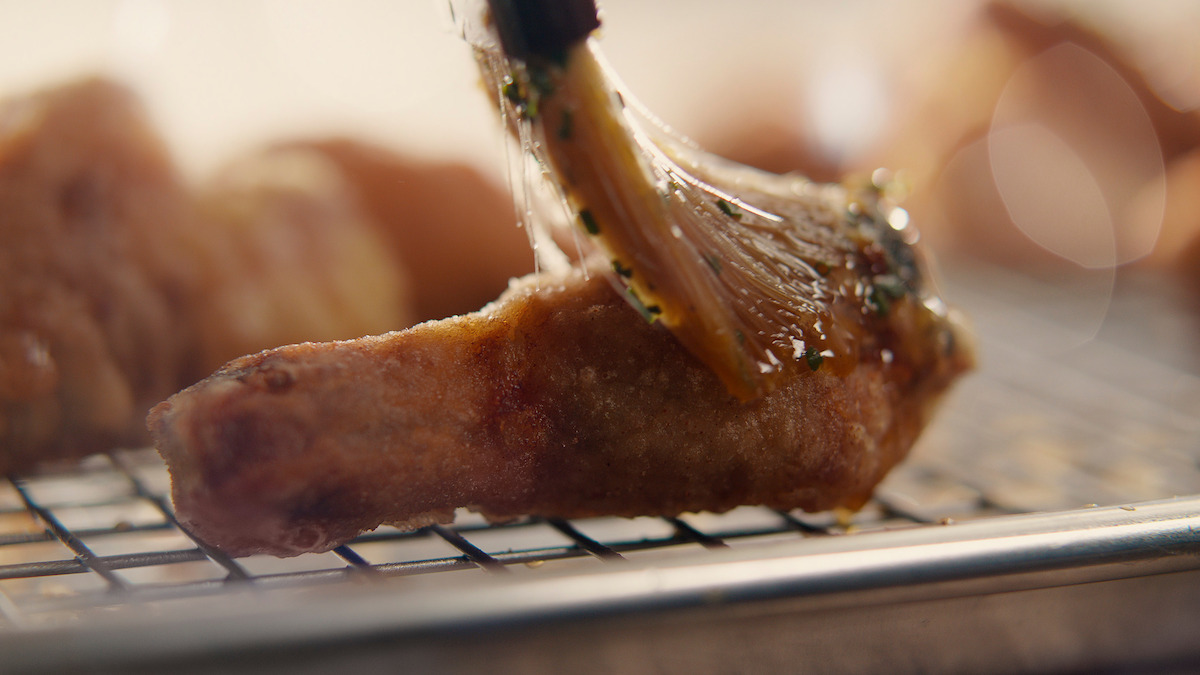 Korean crying tiger sauce being spread onto fried chicken.