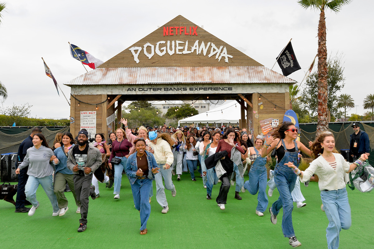 Fans running through the Poguelandia entrance at Netflix’s Poguelandia 2024: A Netflix Outer Banks Experience at Barker Hangar on Nov. 2 in Santa Monica, California.