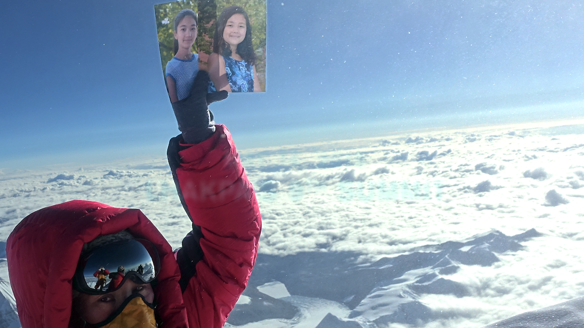 Lhakpa Sherpa holding photos of Sunny and Shiny.