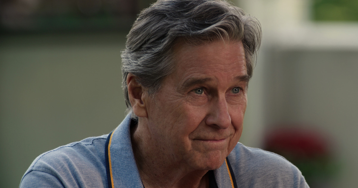 Tim Matheson smiles gently at someone.
