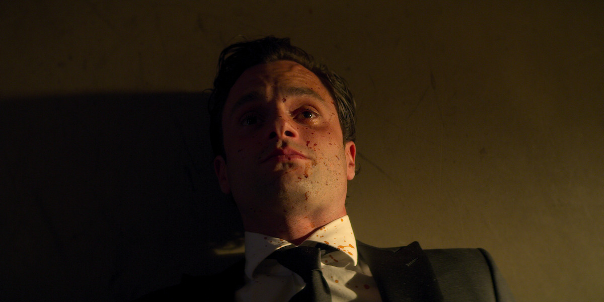 A blood-splattered Joe (Penn Badgley) on his back on the floor