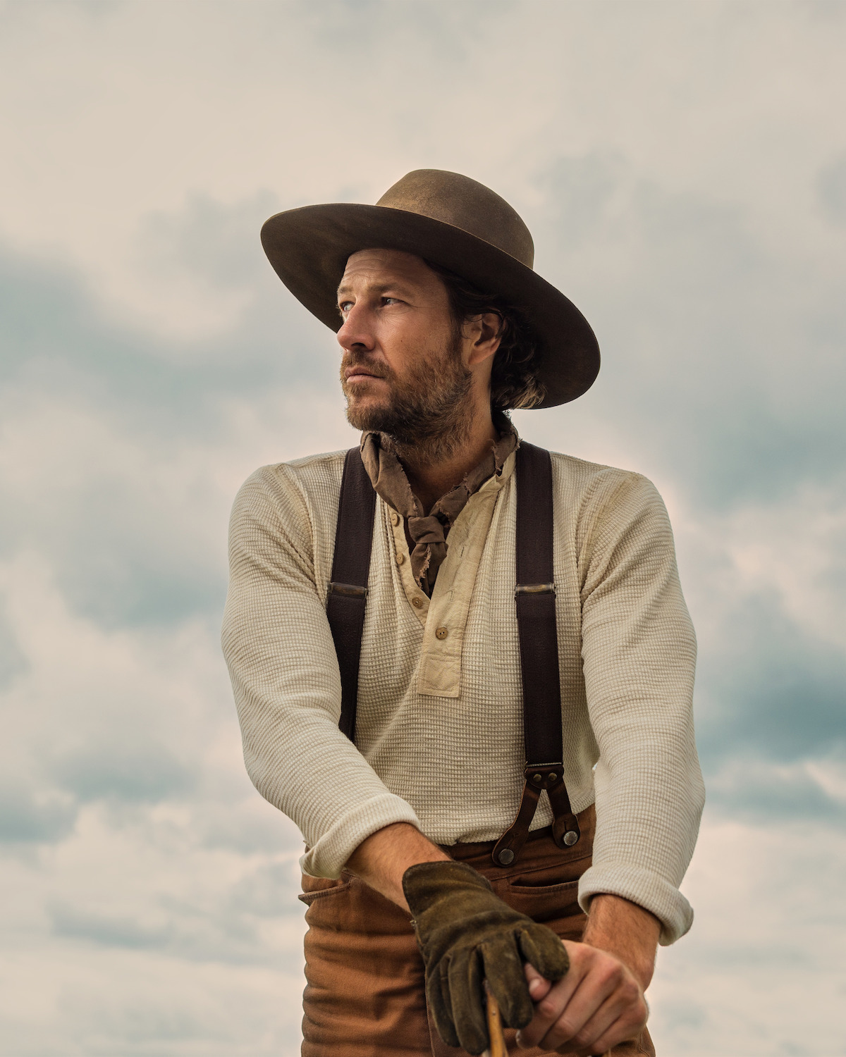 A man in a hat looks off to the side.
