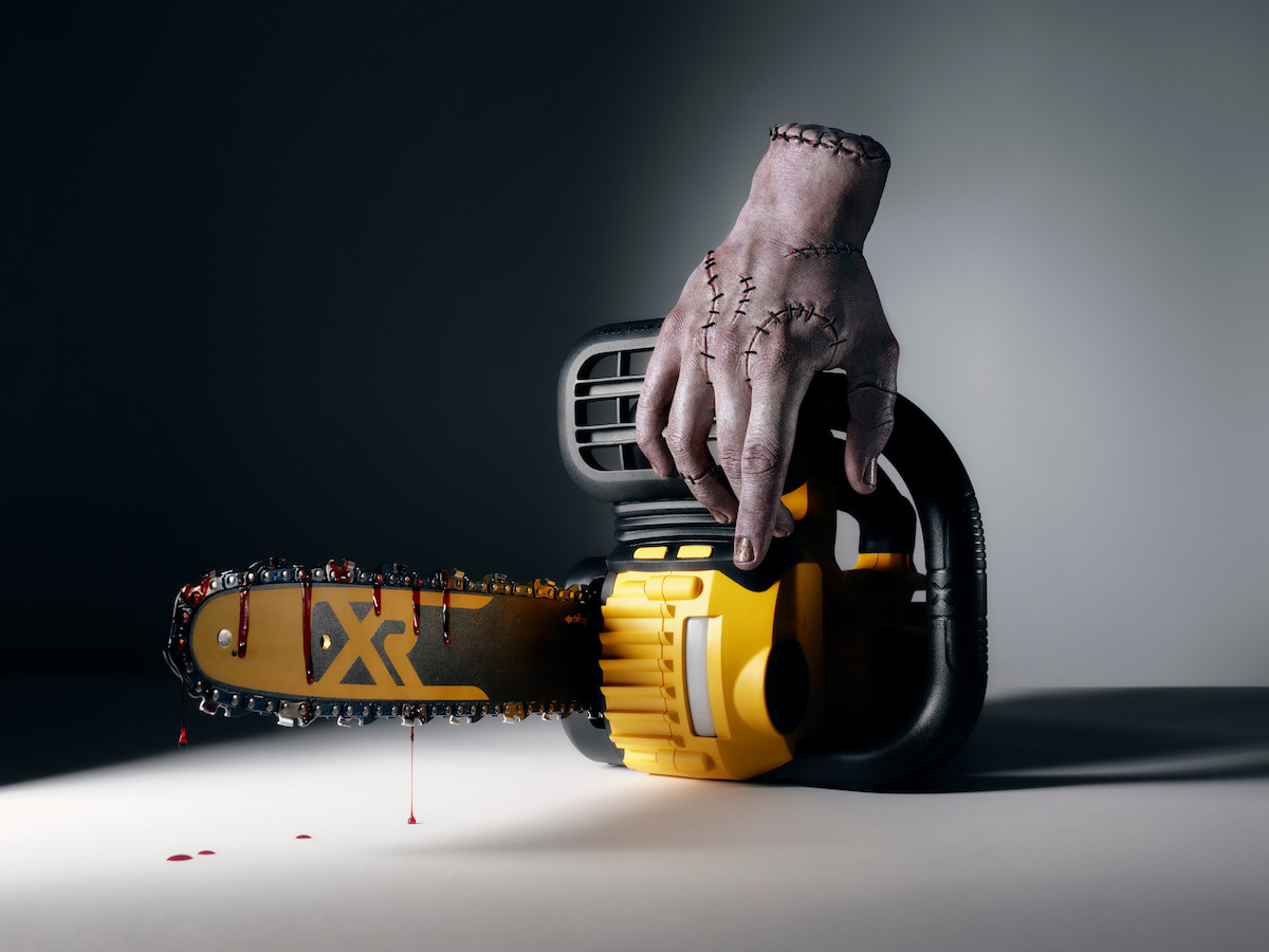 Thing on a yellow chainsaw with a bloody blade.