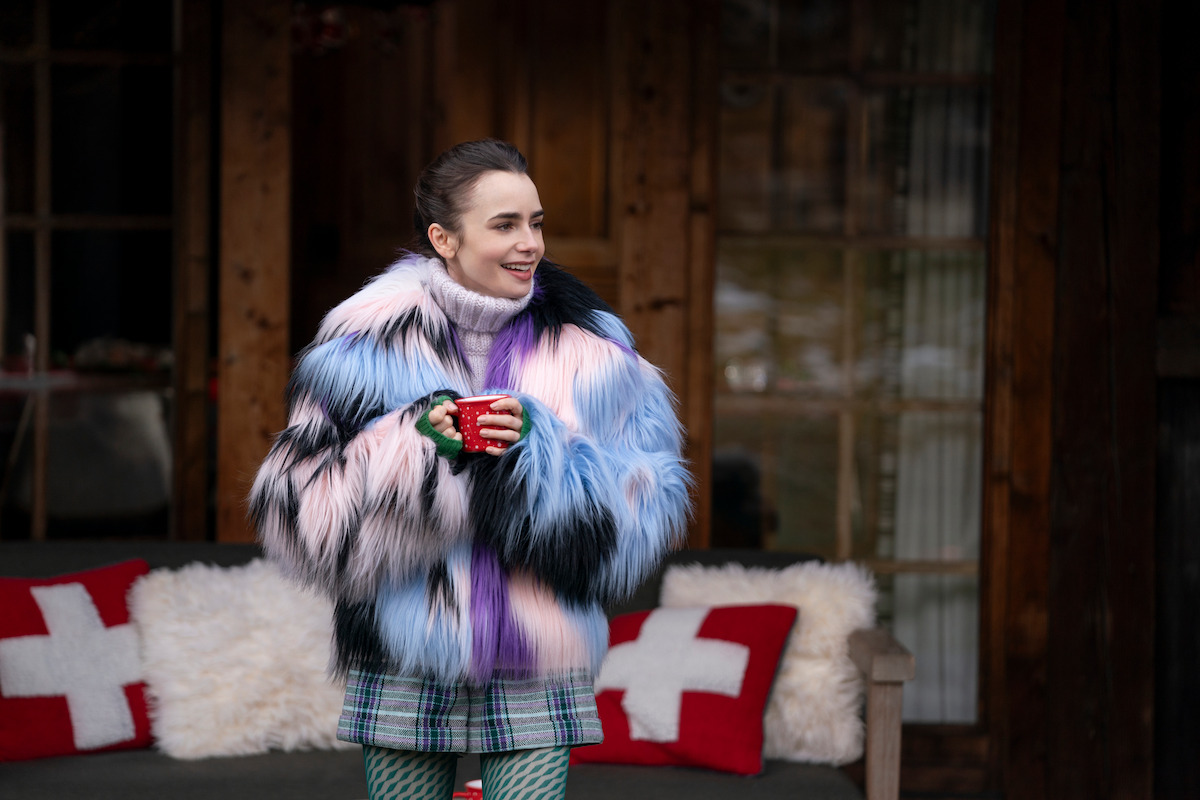 Lily Collins as Emily wears a plue and purple furry winter coat in Season 4 of ‘Emily in Paris’