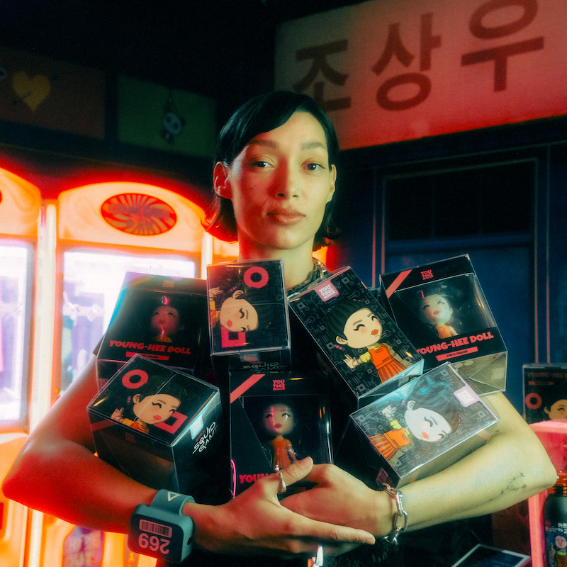 A person is holding several mini versions of the Young-Hee Doll