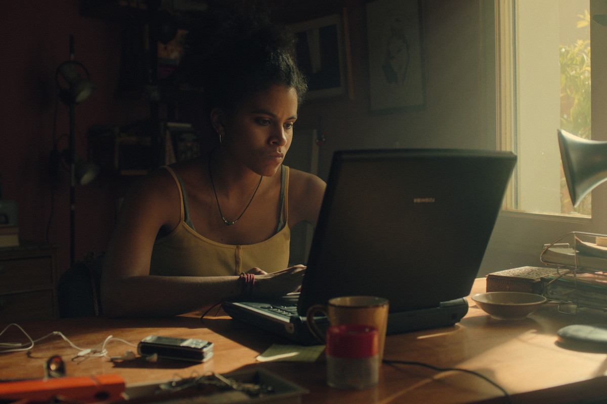 Zazie Beetz as Bo in Black Mirror Season 6 sitting at computer desk.
