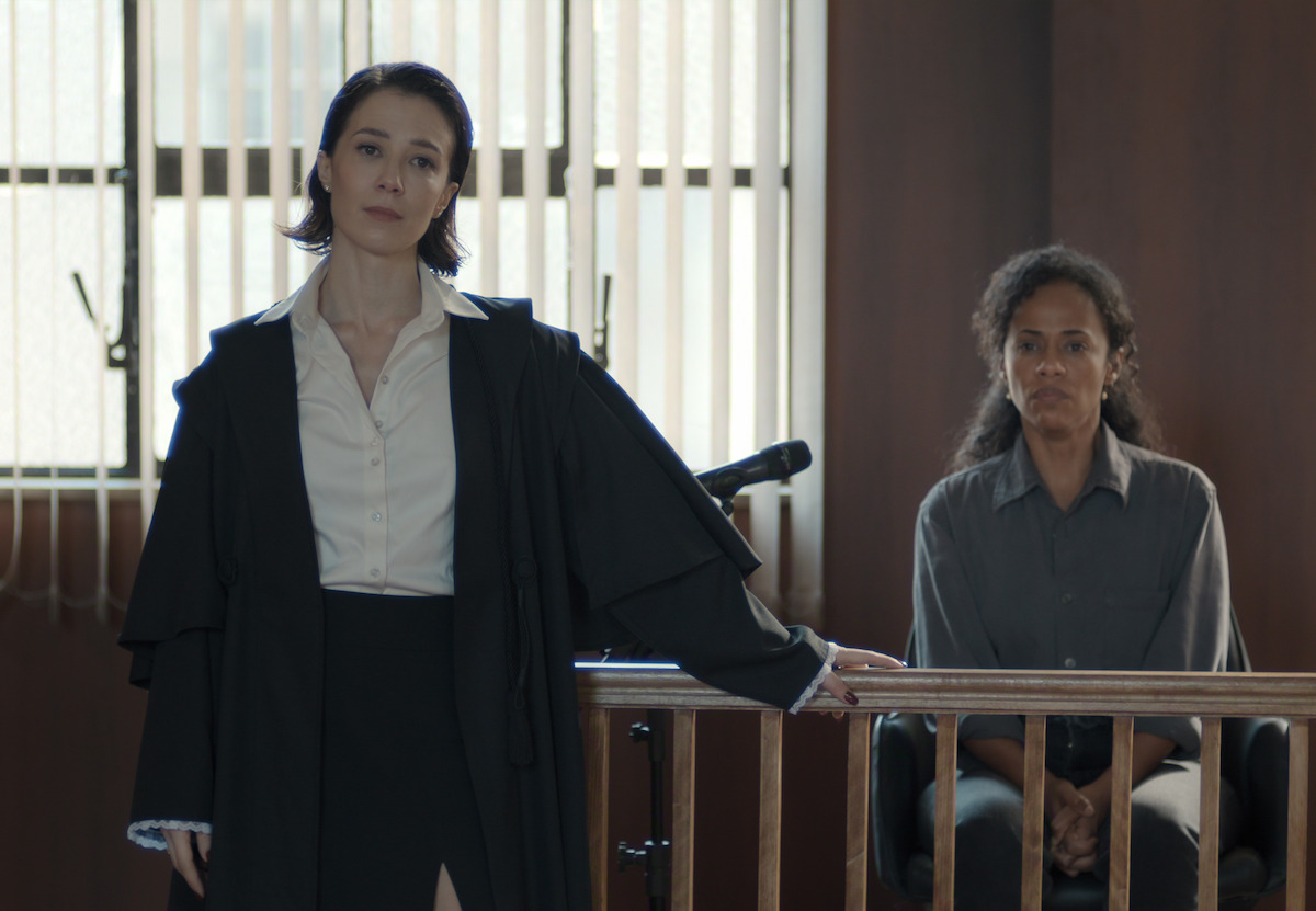 Duas mulheres, as atrizes Marjorie Estinao e Naruna Costa, posam lado a lado em um tribunal