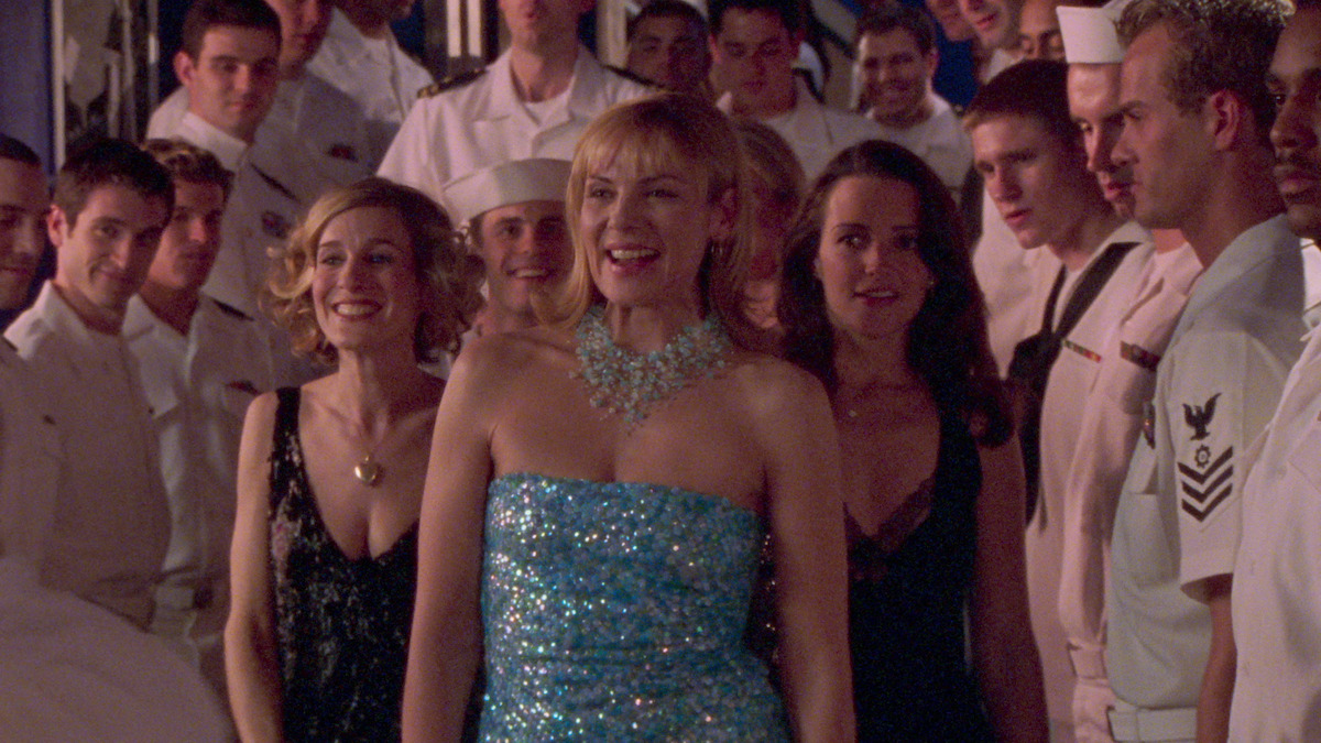 Samantha in a glittery dress, with Carrie and Charlotte standing behind her. 