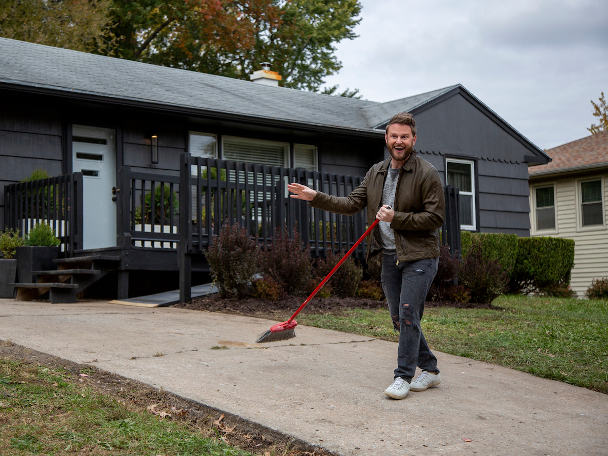 a man sweeping up the driveway
