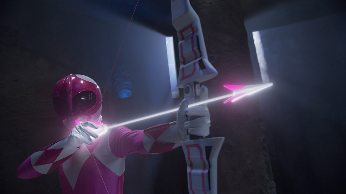 Pink Ranger Kat Hillard (Catherine Sutherland) takes aim with a bow and glowing pink arrow.