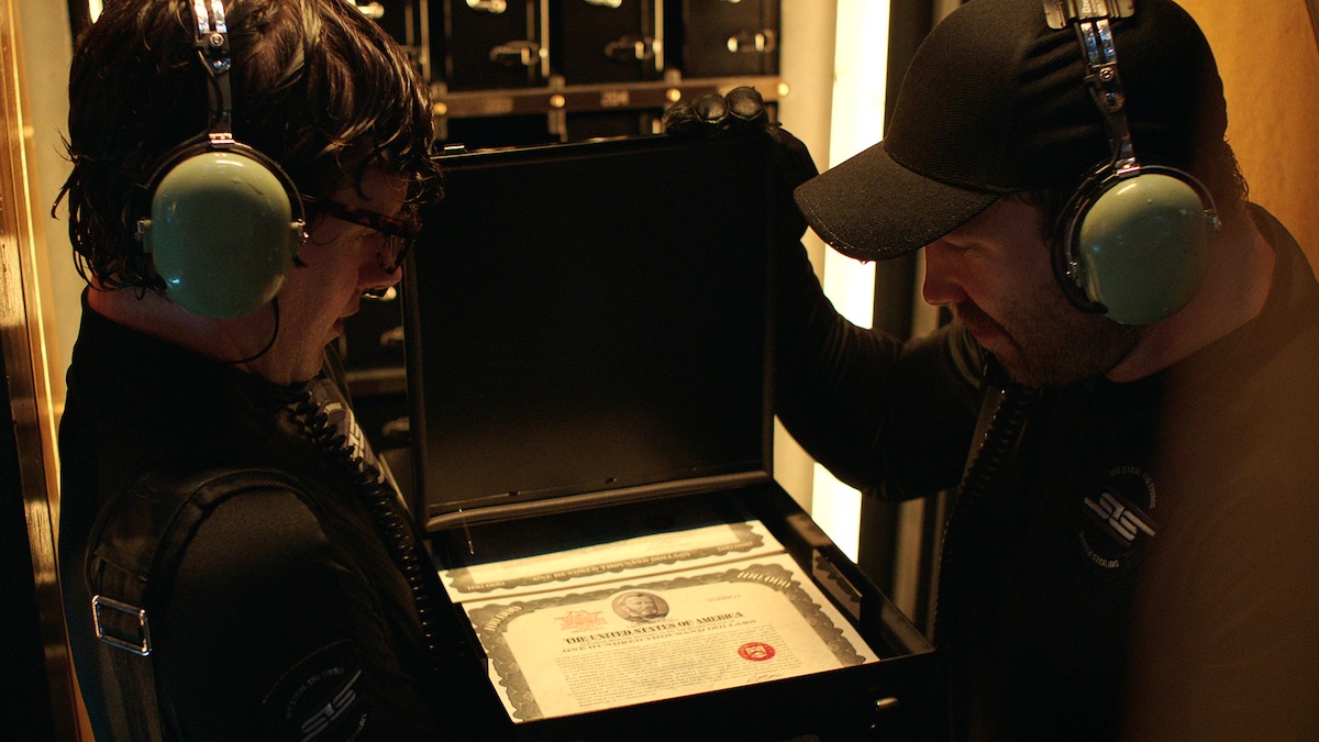 Two people wearing hearing protection looking down lovingly at bearer bonds.