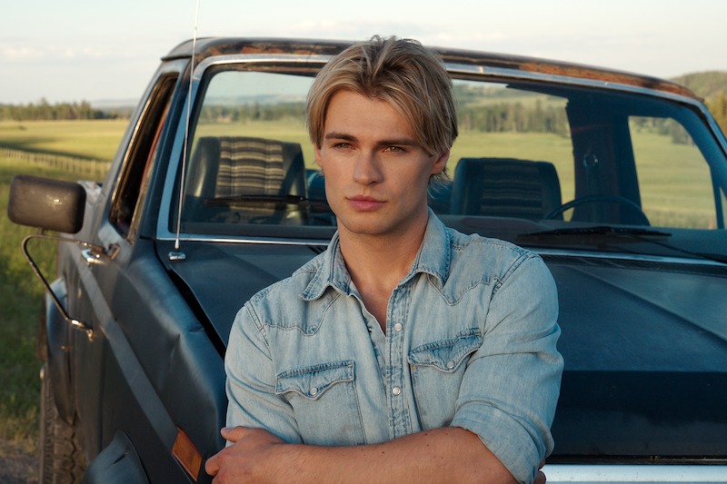 LaLonde as Cole in a denim shirt leaning against a truck in a rural setting in 'My Life with the Walter Boys' Season 2