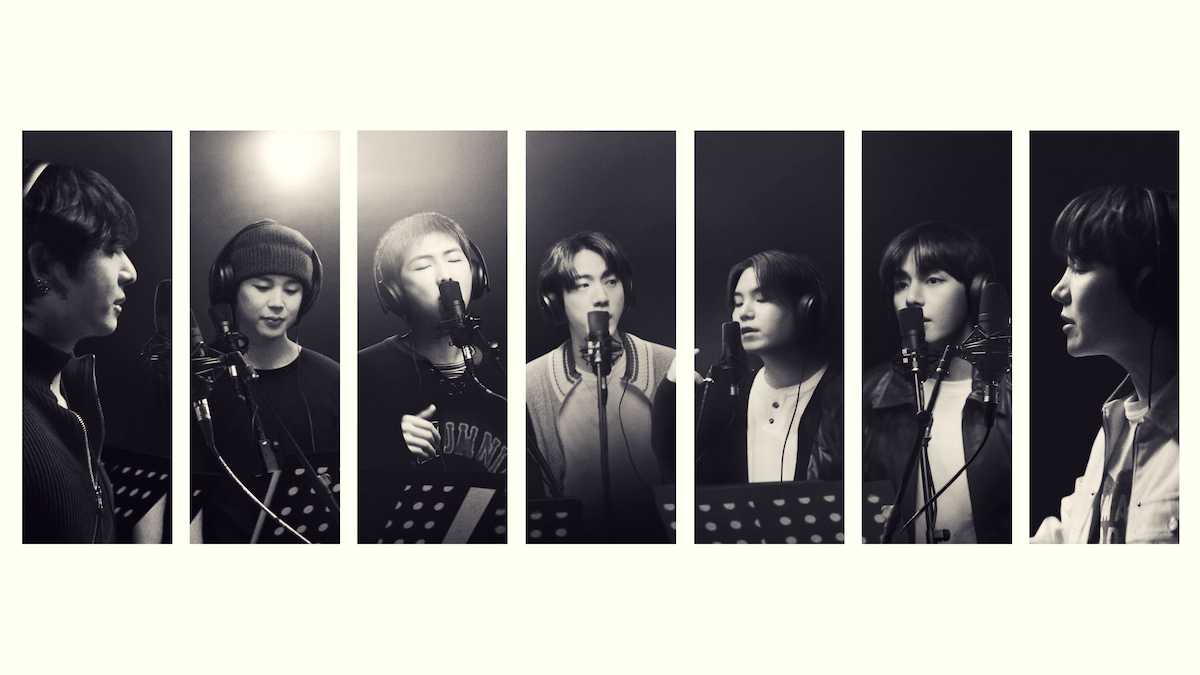 Seven people in a recording studio, each standing at a microphone with music stands, singing or speaking, black and white, portrait orientation, individual spotlight on each person, professional, creative environment.