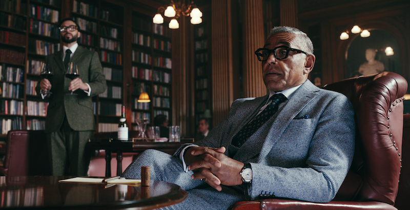 Giancarlo Esposito sits on a red leather chair in a grand office in Season 1 of ‘The Gentlemen.’