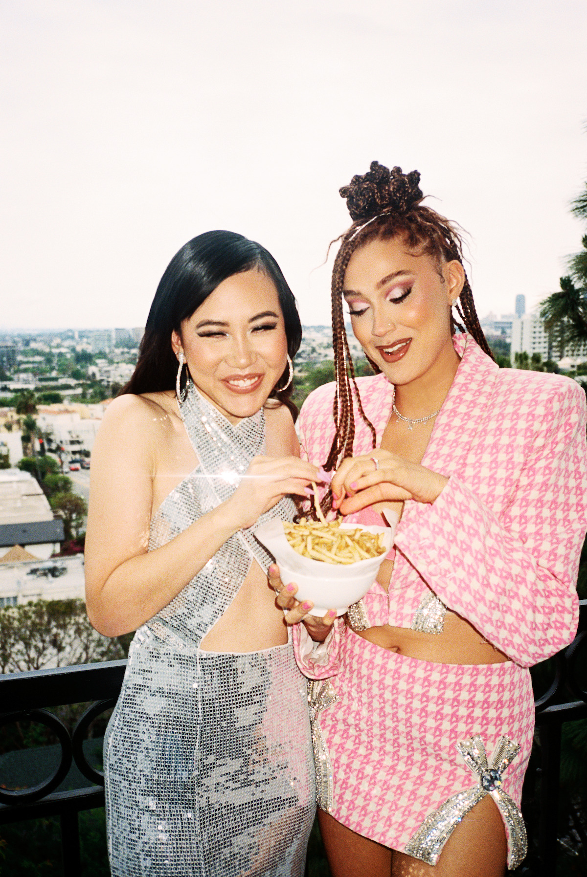 Ramona Young and Lee Rodriguez eating french fries on the balcony.