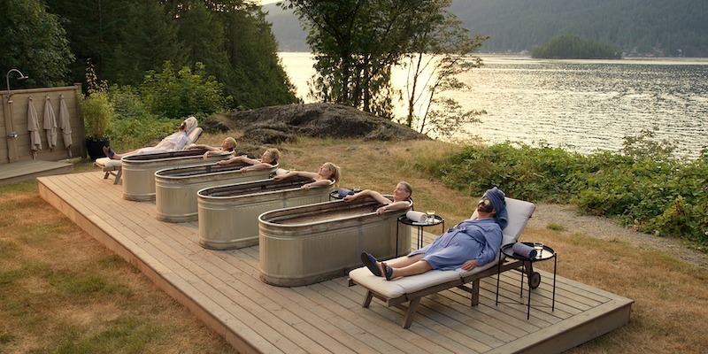 Christina Jastrzembska as Lydie, Teryl Rothery as Muriel St. Claire, Gwynyth Walsh as Jo Ellen, Sarah Dugdale as Lizzie, Annette O’Toole as Hope, Nicola Cavendish as Connie lay outside in bathtubs and lounge chairs in Season 5 of ‘Virgin River.’