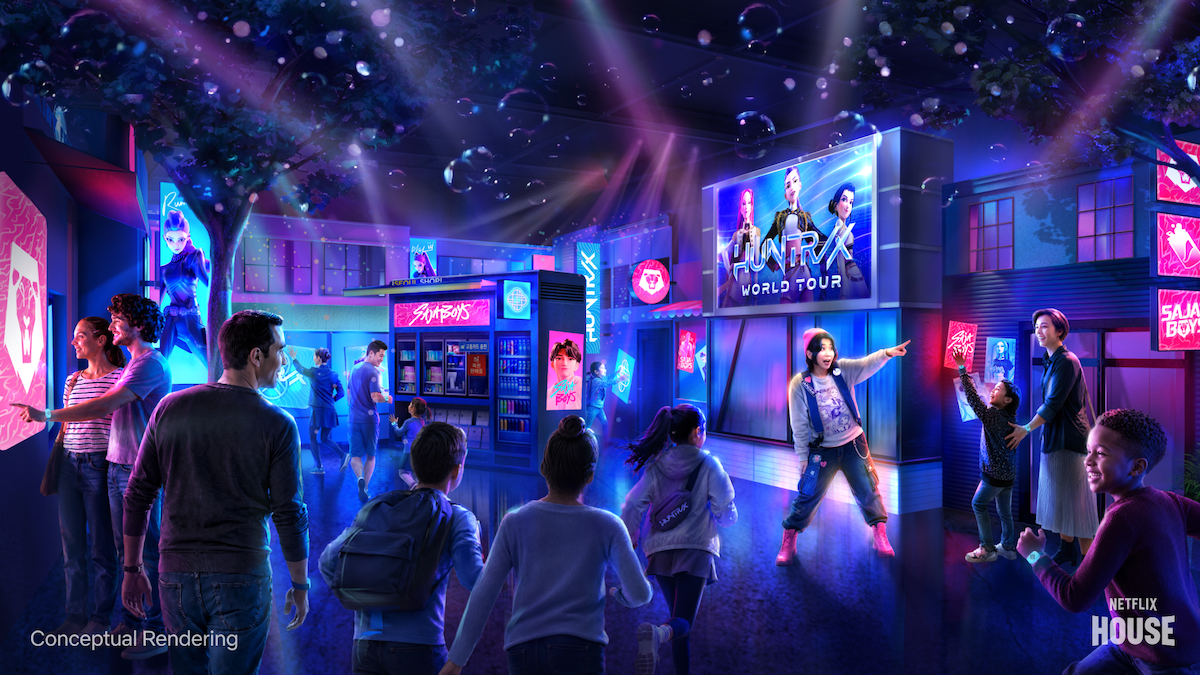 People walk through a vibrant, futuristic indoor entertainment space with neon lights, digital screens, and Netflix-themed signage, creating an immersive family-friendly environment.