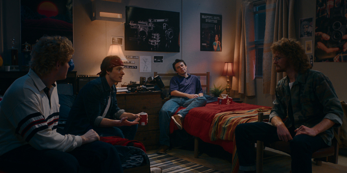 Wyatt Dorion as Chris Di Cesare, Cooper Levy as Craig, Ariel Barrios as Paul, and Rhys Alexander Phillips as Jeff Ungar hang out in a dorm room drinking beer in ‘True Haunting.’