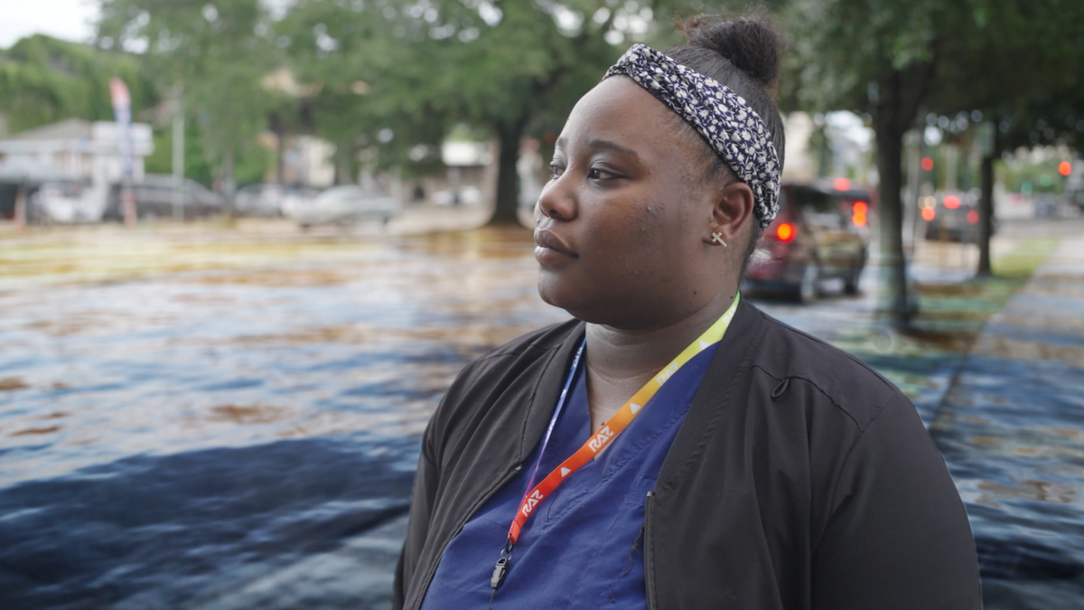 A woman looks out over a flooded street.