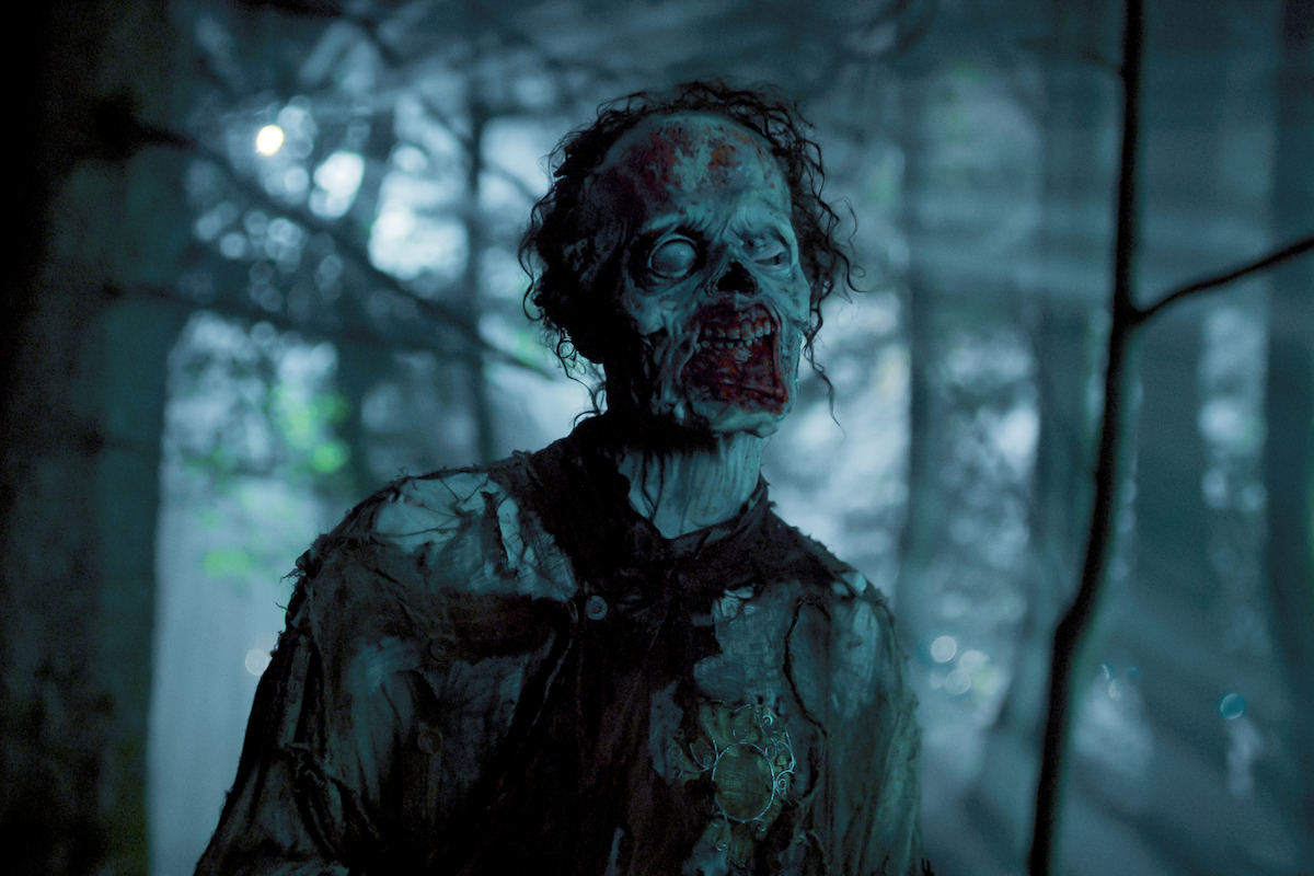 Owen Painter as Slurp, a zombie, walks through the woods at night in ‘Wednesday’ Season 2.