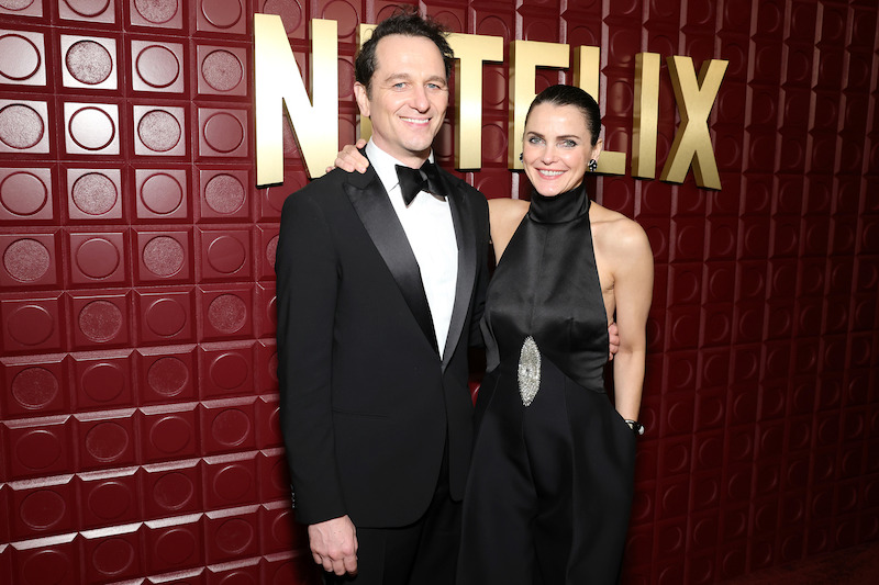 Matthew Rhys and Keri Russell stand in front of a red backdrop