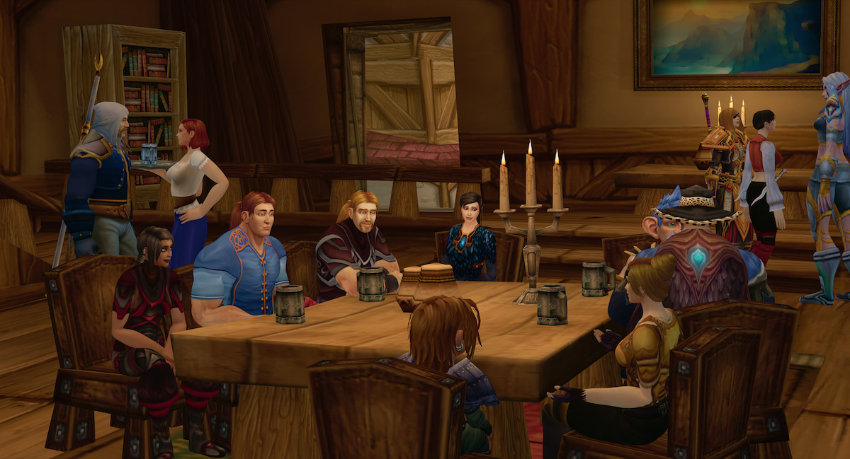 Ibelin Redmoore sits around with his friends at a wood table.