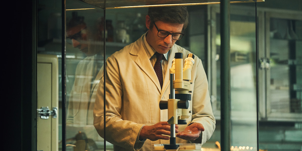 Robert Edwards (James Norton) looks through a microscope.