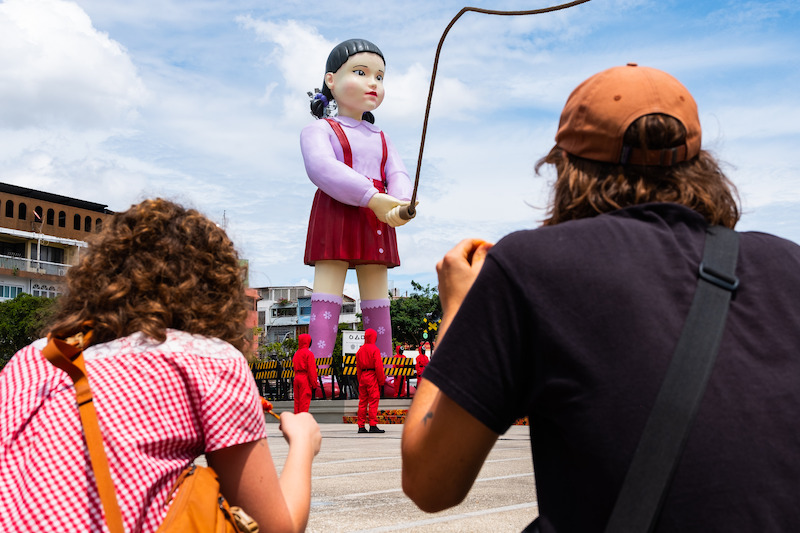 Fans cheer on competitors during the Giant Jump Rope Game at a 'Squid Game' Season 3 event in Bangkok.
